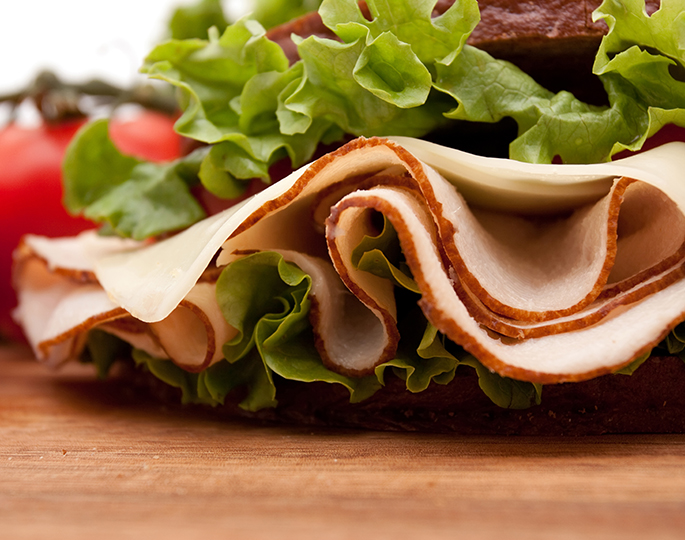 Nærbilde av brødskive med salat, hvitost og kalkun.Foto