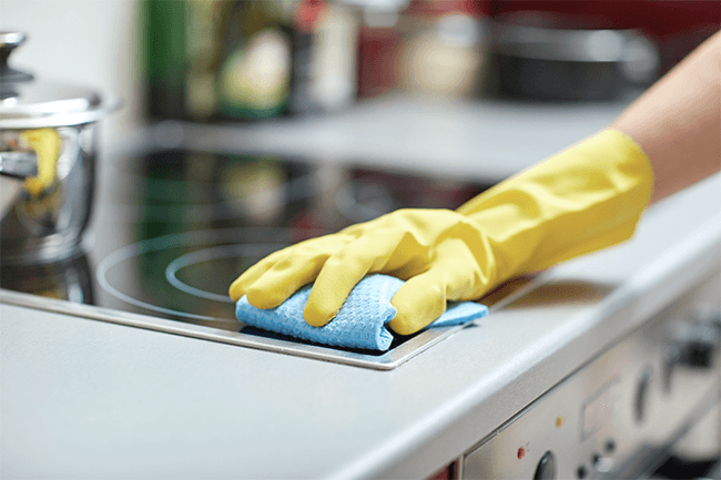 Person rengjør ovn på kjøkkenet.Foto