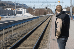 Mann venter på toget.Foto