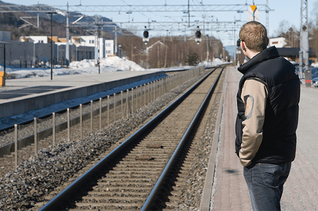 Mann venter på toget.Foto