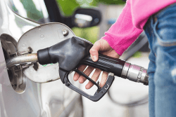 Kvinne fyller diesel på bilen.Foto