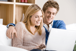 Par sitter sammen med laptop.Foto