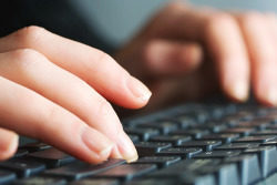 Dame sitter på PC.Foto