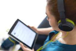 Jente bruker streamingtjeneste på nettbrett.Foto