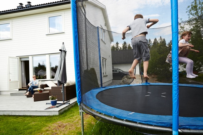 Barn leker på trampoline.Foto