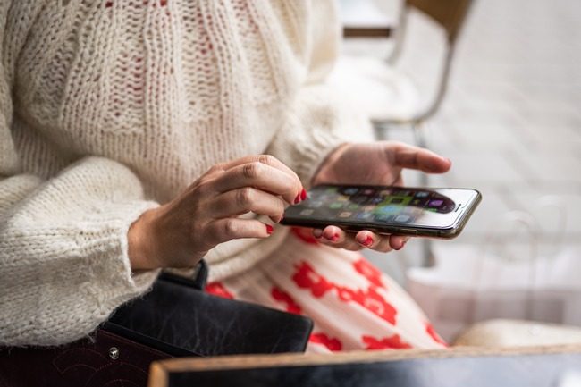Nærbilde av hender som holder en smarttelefon.Foto