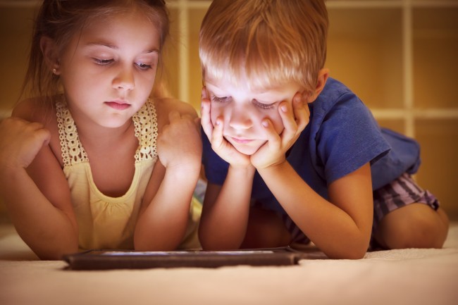 To barn ser på nettbrett.Foto