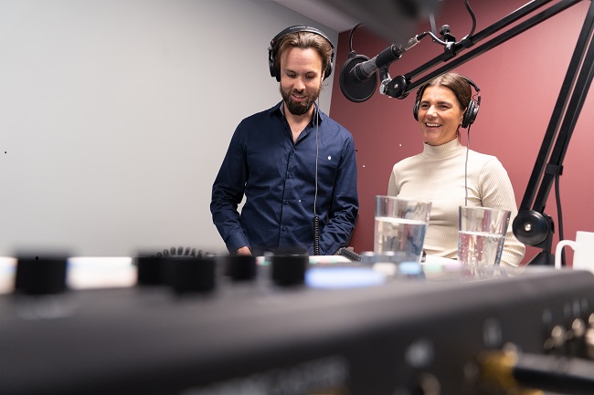 Berit Aamodt og Thomas Iversen ved mikrofon i podkaststudio