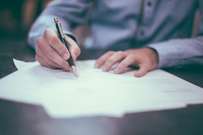 Illustrasjonsfoto av en person som er i ferd med å skrive under på en kontrakt.