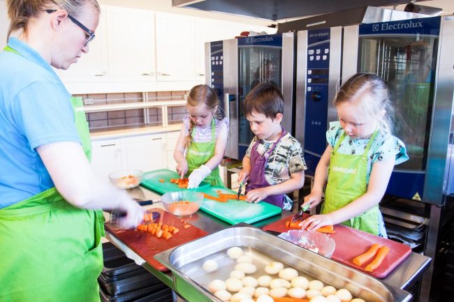 Barn lager mat i barnehage.Foto