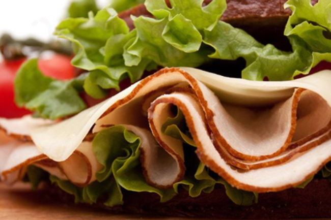 llustrasjonsfoto: Nærbilde av en brødskive med kalkunpålegg og salat.foto