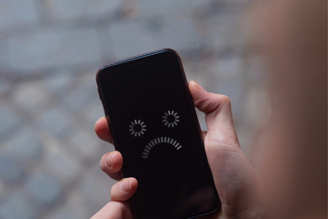 Illustrasjon av en mobiltelefon med surt smilefjes som ikke virker.foto