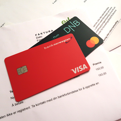Kredittkort som ligger oppå regninger.Foto